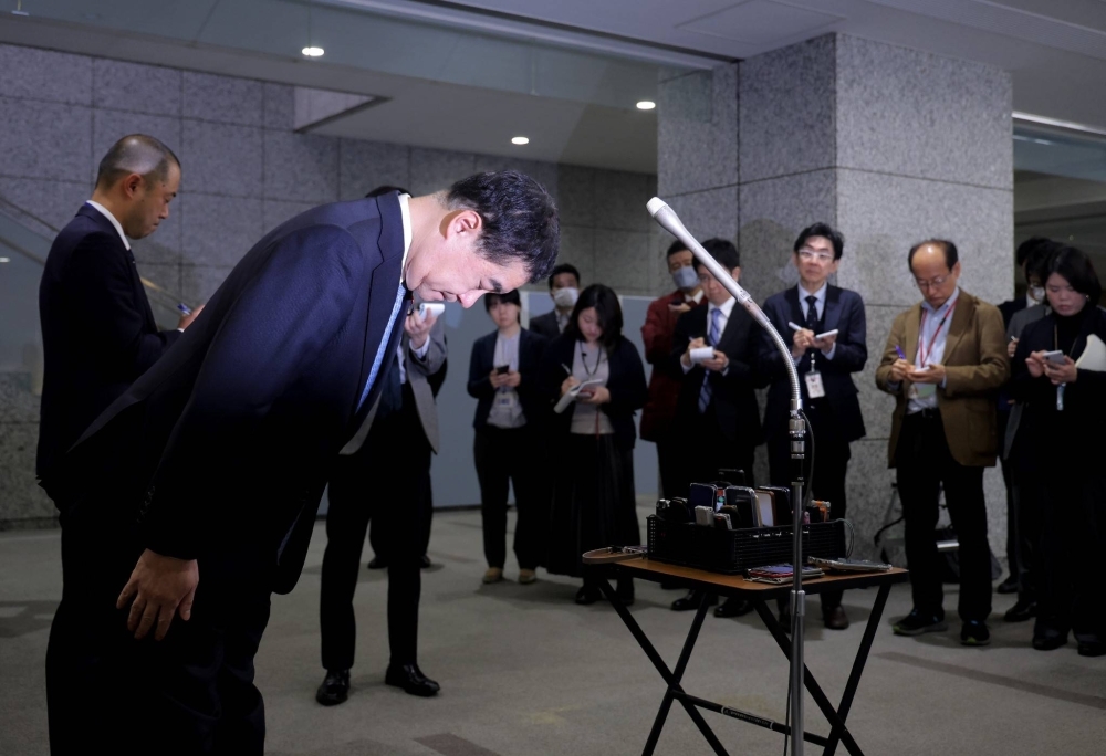 Takuo Komori, parliamentary vice minister for internal affairs, bows after speaking to reporters in Tokyo on Wednesday.