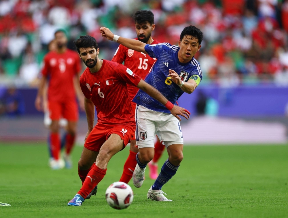 Japan's Wataru Endo (right) and Bahrain's Mohamed Al-Hardan vie for the ball during their Asian Cup match in Doha on Wednesday.