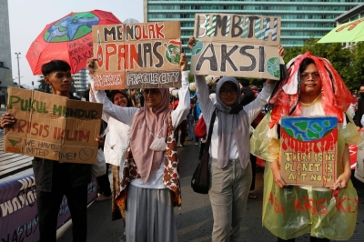 Activists hold placards during a rally ahead of environment day in Jakarta on June 4, 2023. 
