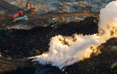 A construction vehicle is seen near a steaming lava flow following a volcanic eruption on the edge of Grindavik, Iceland.