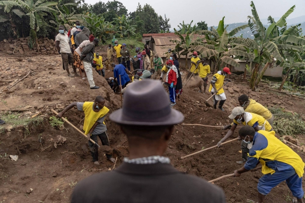 Villagers and volunteers dig for human remains of victims of the 1994 Rwandan genocide.