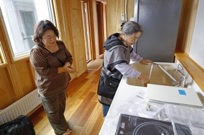 Naomi Oshita (left) and her mother inside a temporary home built for evacuees from the Jan. 1 earthquake that devastated the Noto Peninsula, in Wajima on Saturday. 