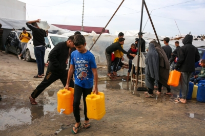 Water jugs are filled at a United Nations Relief and Works Agency camp for displaced Palestinians in Khan Younis, Gaza Strip, on Nov. 22. 