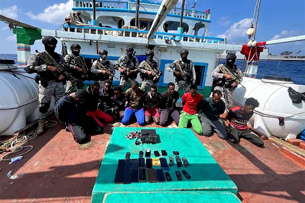 Indian commandos stand guard with a group of detained pirates after the Indian Navy freed an Iranian fishing vessel hijacked by Somali pirates on Tuesday. 