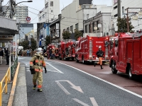 Firefighters near the building that was burned, near Omori Station in Tokyo on Sunday. | Mark Thompson
