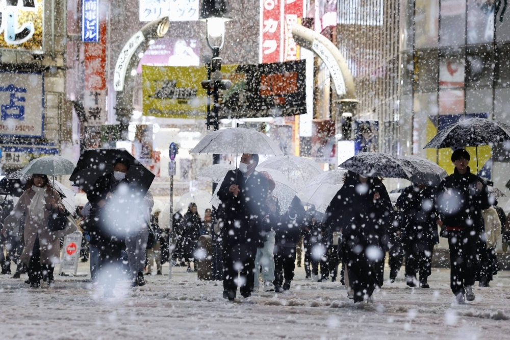 Snow falls over the Shibuya scramble crossing in Tokyo on Monday evening. 