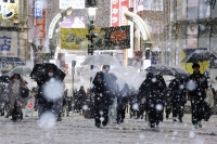 Snow falls over the Shibuya scramble crossing in Tokyo on Monday evening.  | Kyodo 