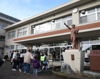 Elementary school students arrive at Wajima Senior High School in Ishikawa Prefecture as classes resume at vacant classrooms at the school on Tuesday. | Jiji