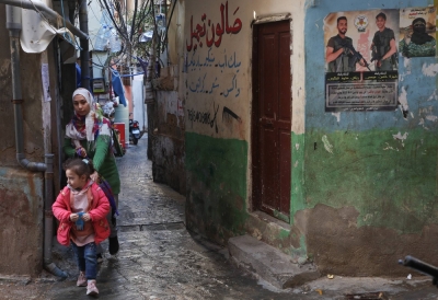 A Palestinian woman walks with a child at Mar Elias refugee camp in Beirut on Jan. 29. 