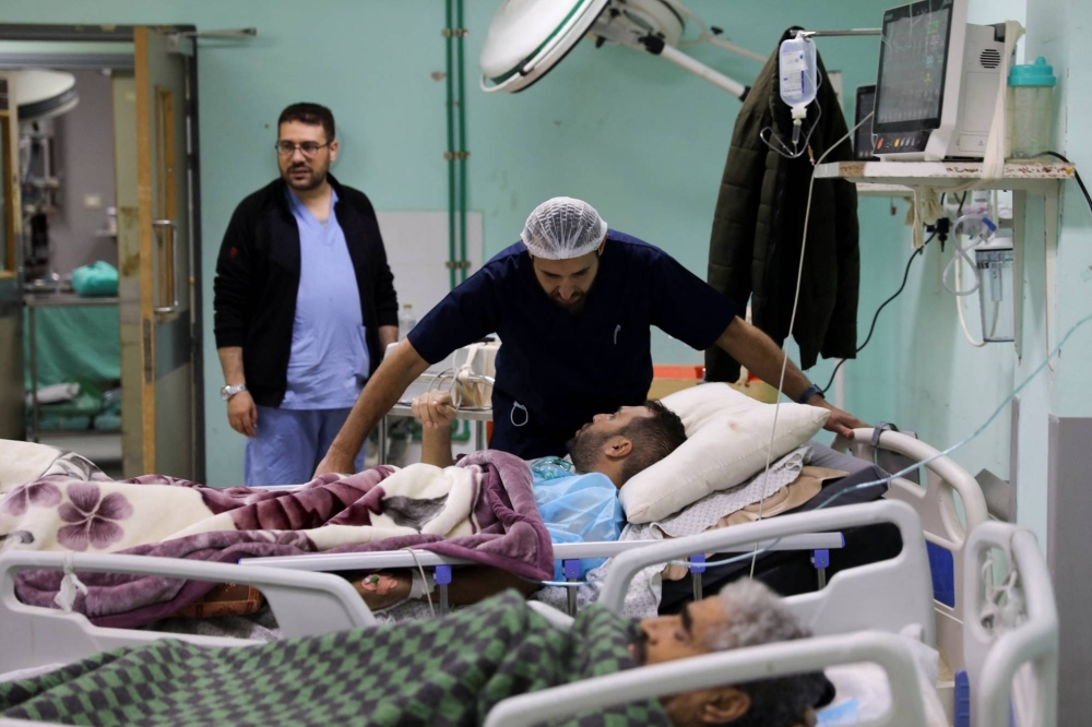 Palestinian Irish plastic surgeon Ahmed El Mokhallalati checks a Palestinian man wounded in an Israeli strike, at the European Hospital, in Khan Younis in the southern Gaza Strip.