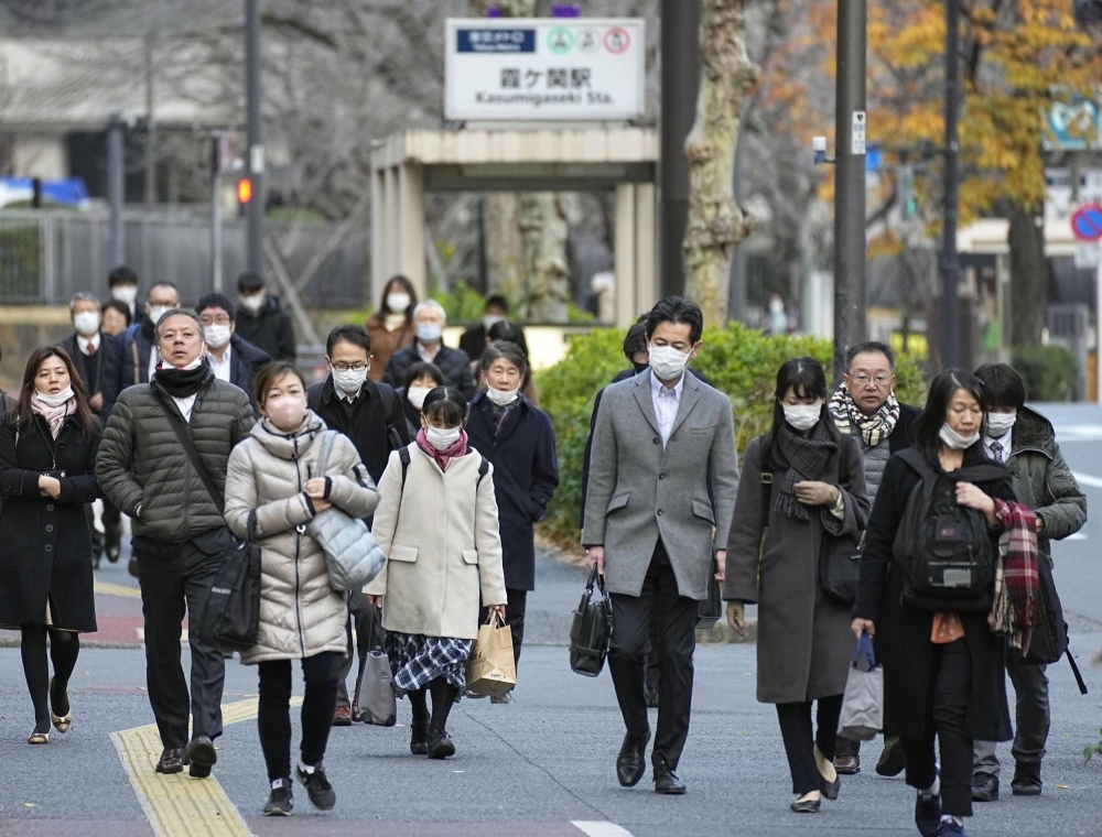Commuters head to work in Tokyo's Kasumigaseki district where government ministries are located. The government plans to issue a guideline to encourage diverse ways of working, including working remotely, among its employees.
