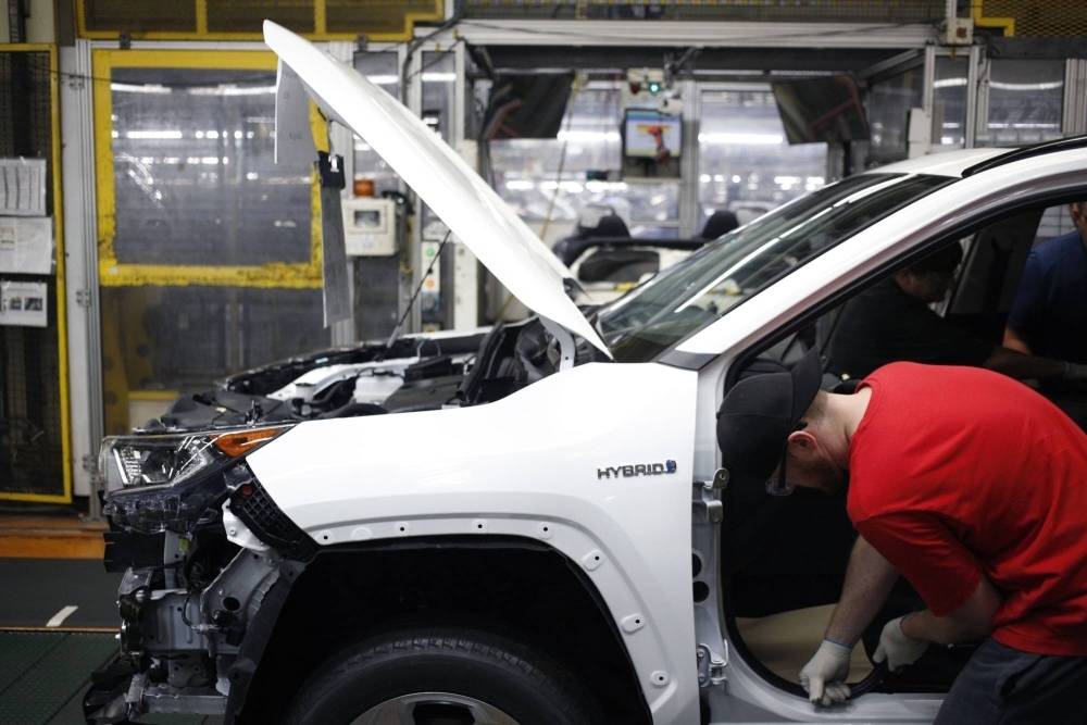 Workers install components on a RAV4 hybrid sport utility vehicle at the Toyota manufacturing plant in Georgetown, Kentucky.