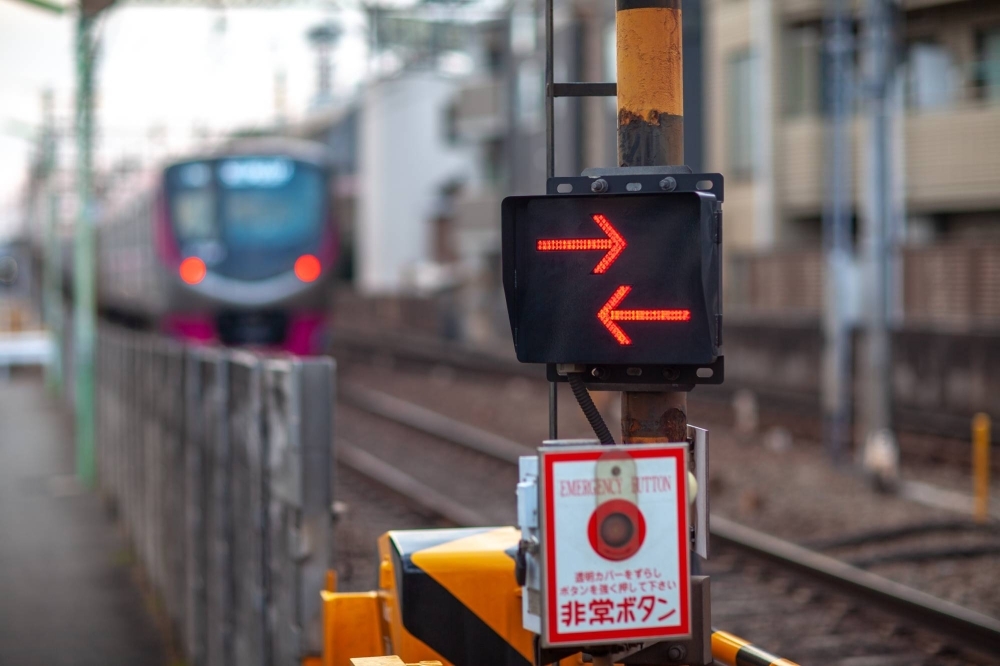 A railway crossing in Japan. A railway crossing gate in Osaka city opened before a train passed through on Tuesday, scraping a car that had proceeded to cross.