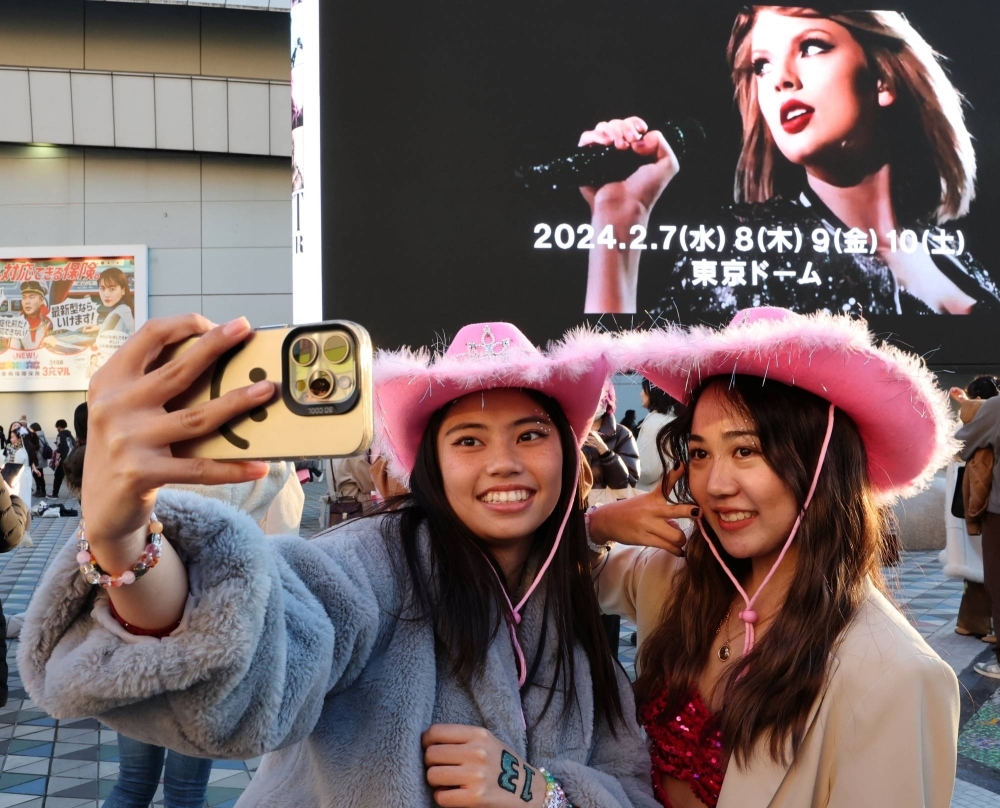 Japanese fans of Taylor Swift take a selfie before entering Tokyo Dome for the pop star's Eras Tour show in Japan on Feb. 7. 