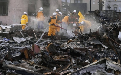 Firefighters remove rubble from the former site of a market in Wajima in Ishikawa Prefecture on Jan. 6, after a fire broke out following a strong earthquake that struck the Noto Peninsula and surrounding areas on Jan. 1.