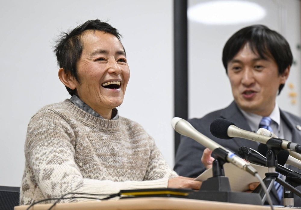 Tacaquito Usui (left) smiles at a news conference in Okayama after the Okayama Family Court's Tsuyama Branch recognized his petition to have his gender changed on his family register on Wednesday.