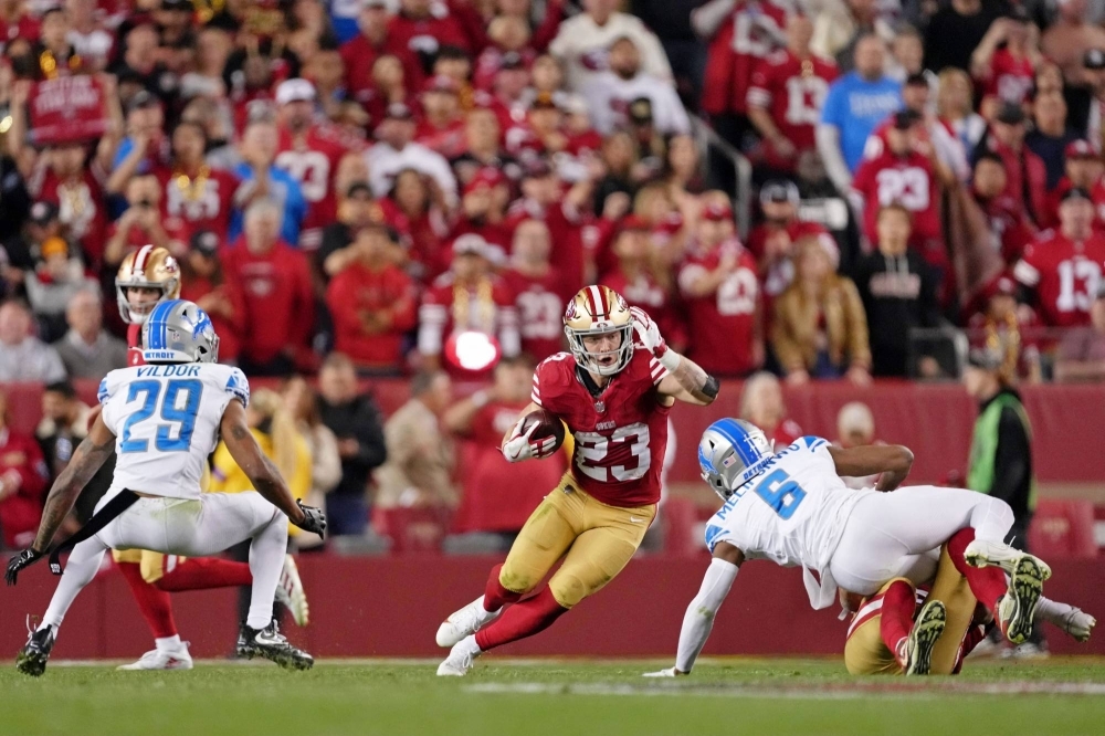 49ers running back Christian McCaffrey runs with the ball during the team's win over the Detroit Lions in the NFC Championship game on Jan. 28. 