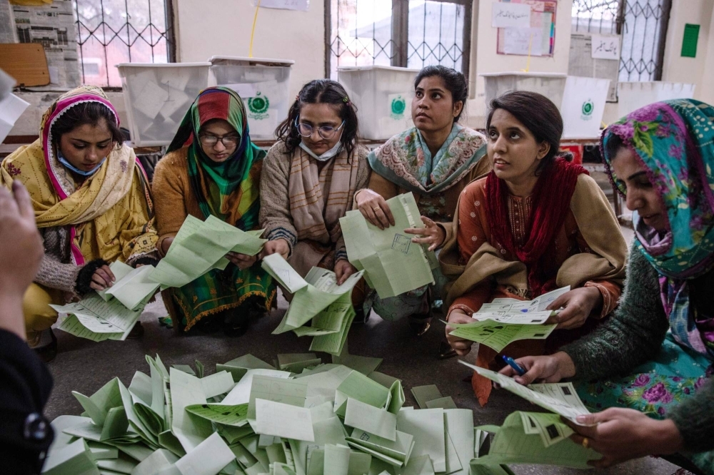 Officials count ballots at a polling station in Lahore, Pakistan, on Thursday.