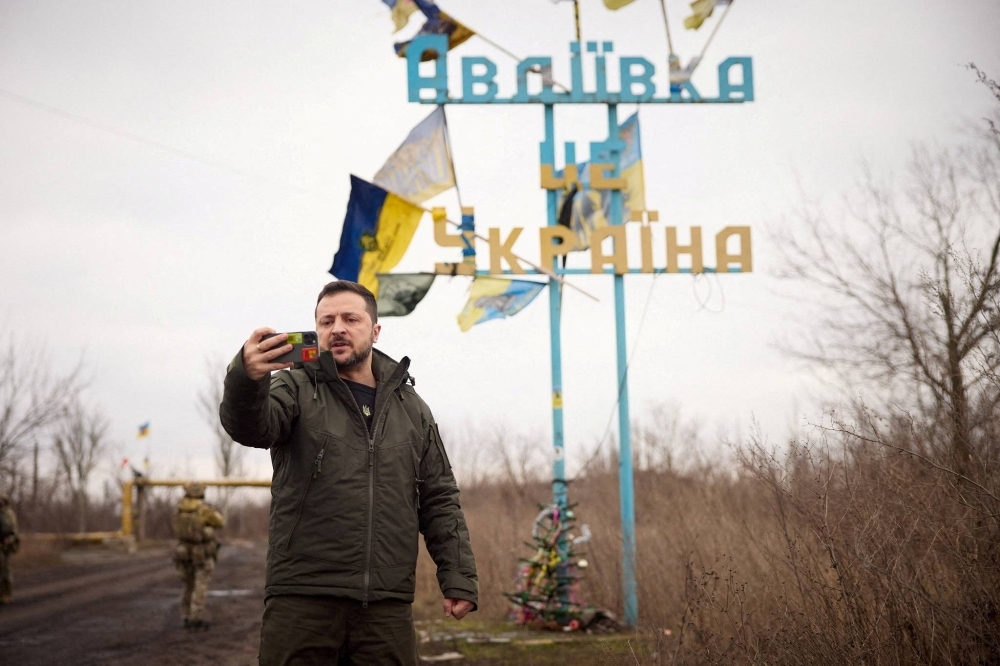 Ukraine President Volodymyr Zelenskyy takes a video in front of a road sign with the words "Avdiivka this is Ukraine" as he visits in the front-line town of Avdiivka Donets region, Ukraine, on Dec. 29.
