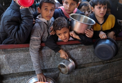 Palestinian children wait to receive food cooked by a charity kitchen in Rafah in the southern Gaza Strip on Monday. 