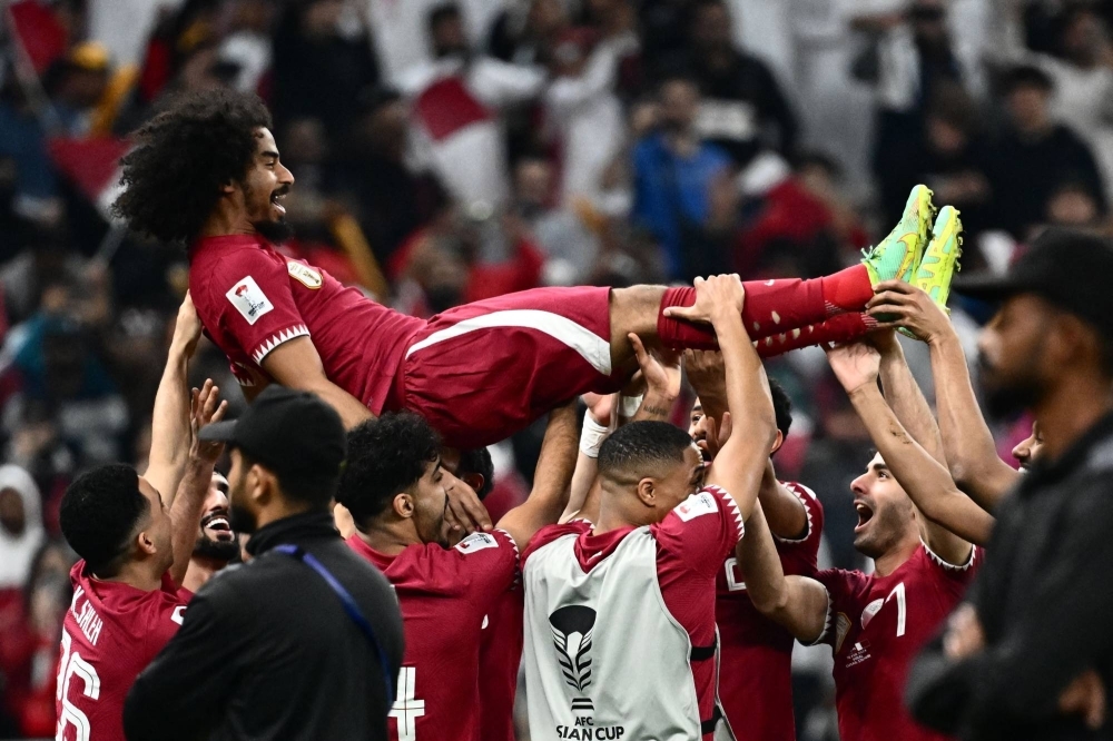 Qatar players celebrate with their hat-trick scorer Akram Afif after the team won the Asian Cup on Saturday in Lusail, near Doha. 