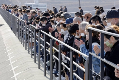 People gather at a park in the city of Rikuzentakata in Iawate Prefecture to pray on March 11 last year, the 12th anniversary of the 2011 earthquake and tsunami disaster.
