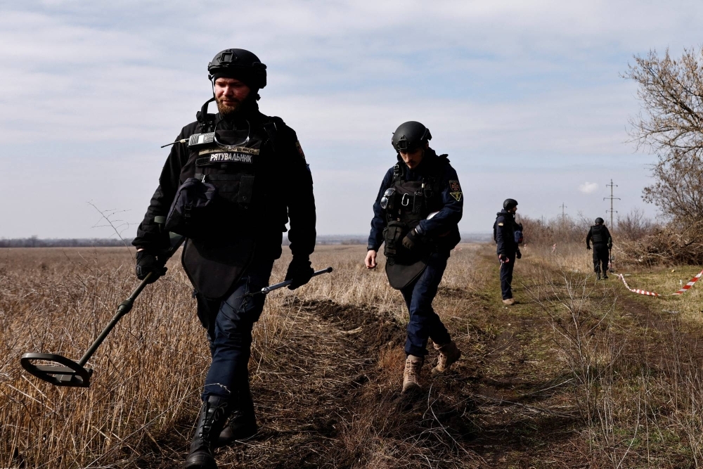 Members of the de-mining department of the Ukrainian Emergency Services survey an area of farmland and electric power lines for land mines and other unexploded ordnance in the Eastern Donetsk region, Ukraine. Japan plans to pledge ¥15.8 billion ($106 million) in aid to support the reconstruction of Ukraine in seven fields such as de-mining.