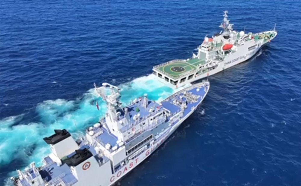 This frame grab from handout video released by the Philippine Coast guard on Feb. 11 shows a Chinese coast guard vessel (front R) blocking and sailing past Philippine coast guard ship BRP Teresa Magbanua (back L) near Scarborough Shoal, in the disputed South China Sea. 