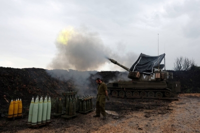 An Israeli soldier stands by as a mobile artillery unit fires, near the Israel-Lebanon border on Jan. 15. 