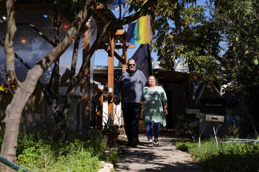 Ayelet Khon and Shar Shnurman walk through Kibbutz Kfar Aza in southern Israel following the Oct. 7 attack by Palestinian Islamist group Hamas, and after they returned to live there, on Jan. 13.