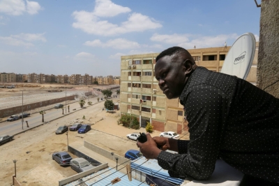 A Sudanese man looks out his balcony in Cairo as he waits for his displaced family to arrive from war-ridden Khartoum, in April.