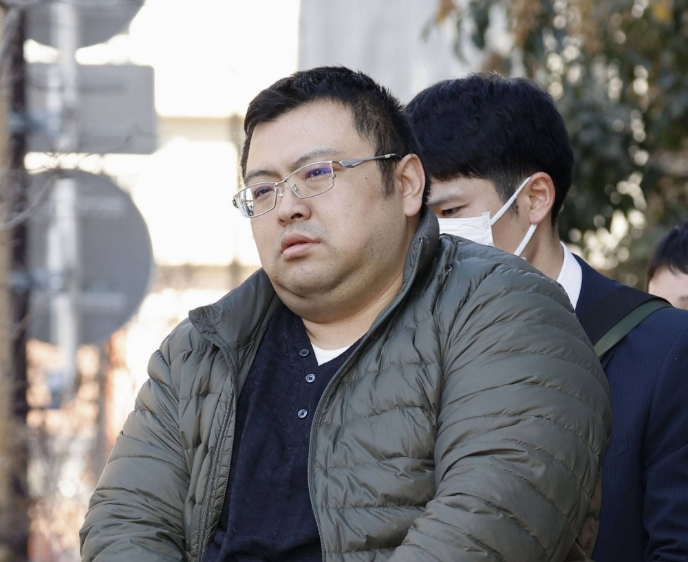 Kenichi Hosoya leaves an apartment in Tokyo's Taito Ward on Wednesday after being arrested.