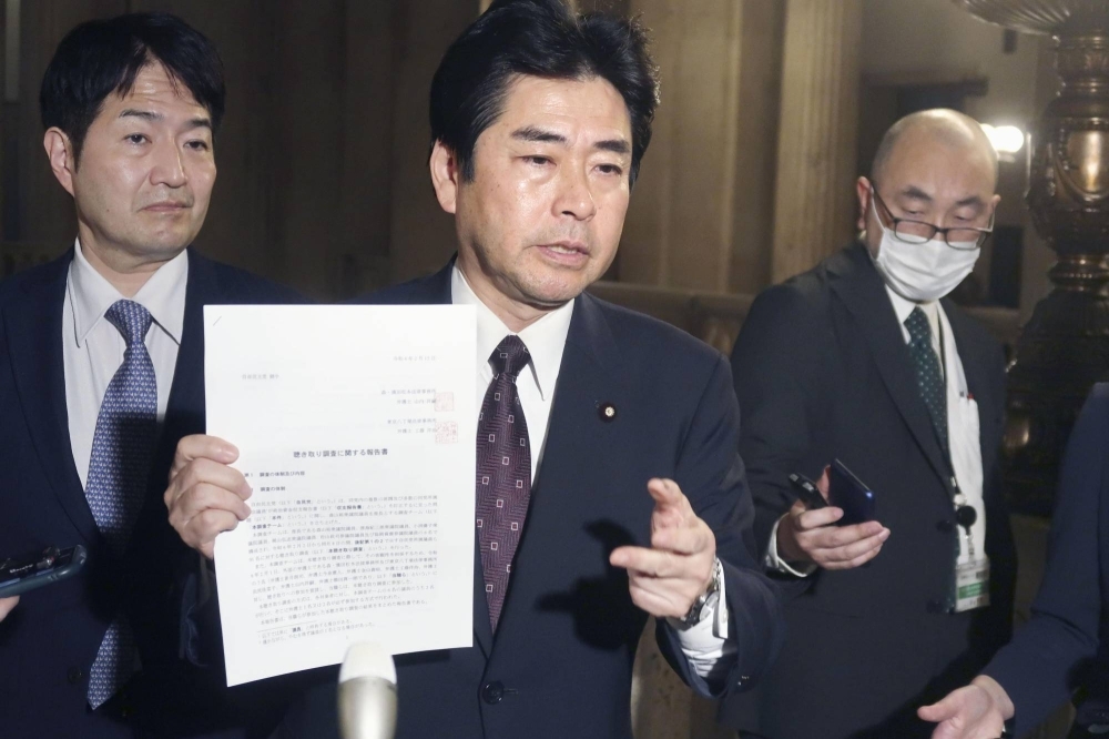 Constitutional Democratic Party of Japan lawmaker Kazunori Yamanoi shows a Liberal Democratic Party survey about a slush funds scandal to reporters in Tokyo on Thursday.