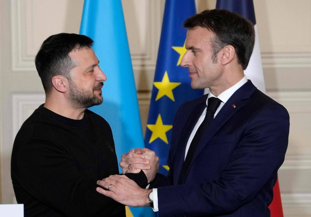 French President Emmanuel Macron shakes hands with Ukrainian leader Volodymyr Zelenskyy during a news conference at the presidential Elysee Palace in Paris on Friday after signing a bilateral security agreement. 