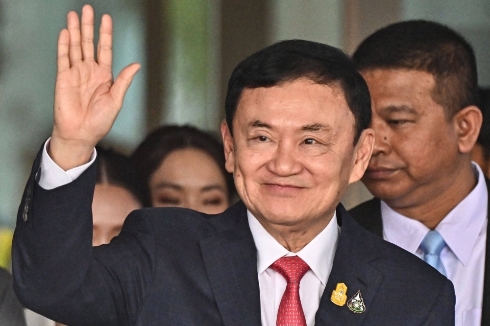 Former Thai Prime Minister Thaksin Shinawatra greets supporters after landing at an airport in Bangkok on Aug. 22.