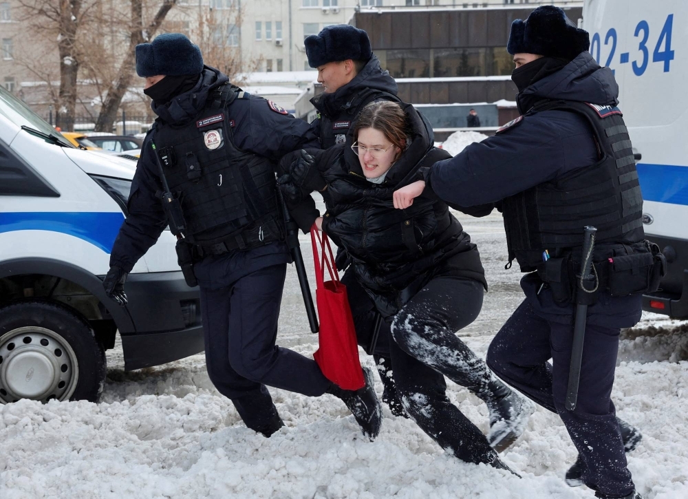 Police officers detain a woman during a gathering in memory of Russian opposition leader Alexei Navalny, near the Wall of Grief in Moscow on Saturday.