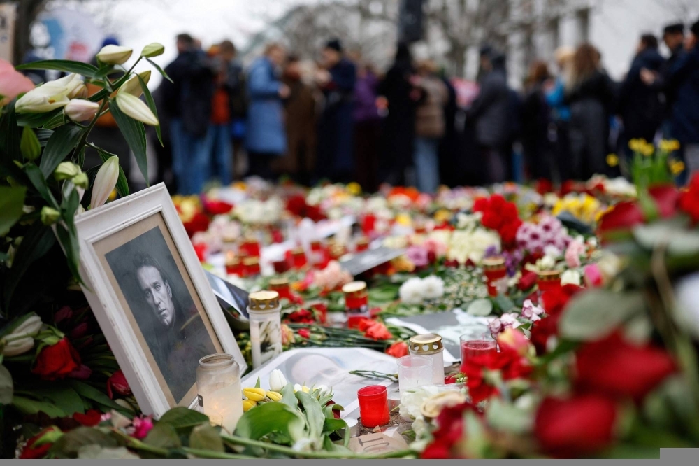 People lay flowers and candles at a memorial in front of the Russian Embassy in Berlin on Sunday, following the death of the Kremlin's most prominent critic Alexei Navalny in an Arctic prison.