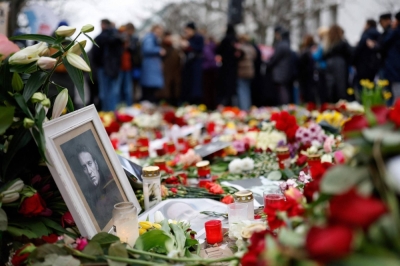 People lay flowers and candles at a memorial in front of the Russian Embassy in Berlin on Sunday, following the death of the Kremlin's most prominent critic Alexei Navalny in an Arctic prison.