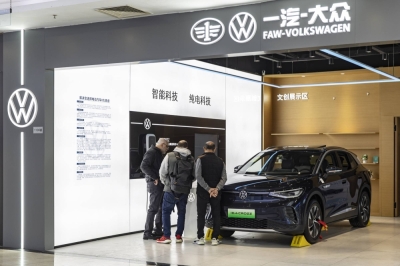 Shoppers walk past an ID Hub, a Volkswagen showroom for electric cars, at a mall in Shanghai on Dec. 3, 2023. 