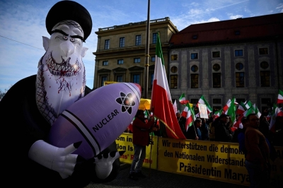 Demonstrators hold Iranian flags and a huge inflated figure representing Iran's Supreme Leader Ali Khamenei holding a nuclear bomb as they protest against the Iranian regime on Friday in Munich.