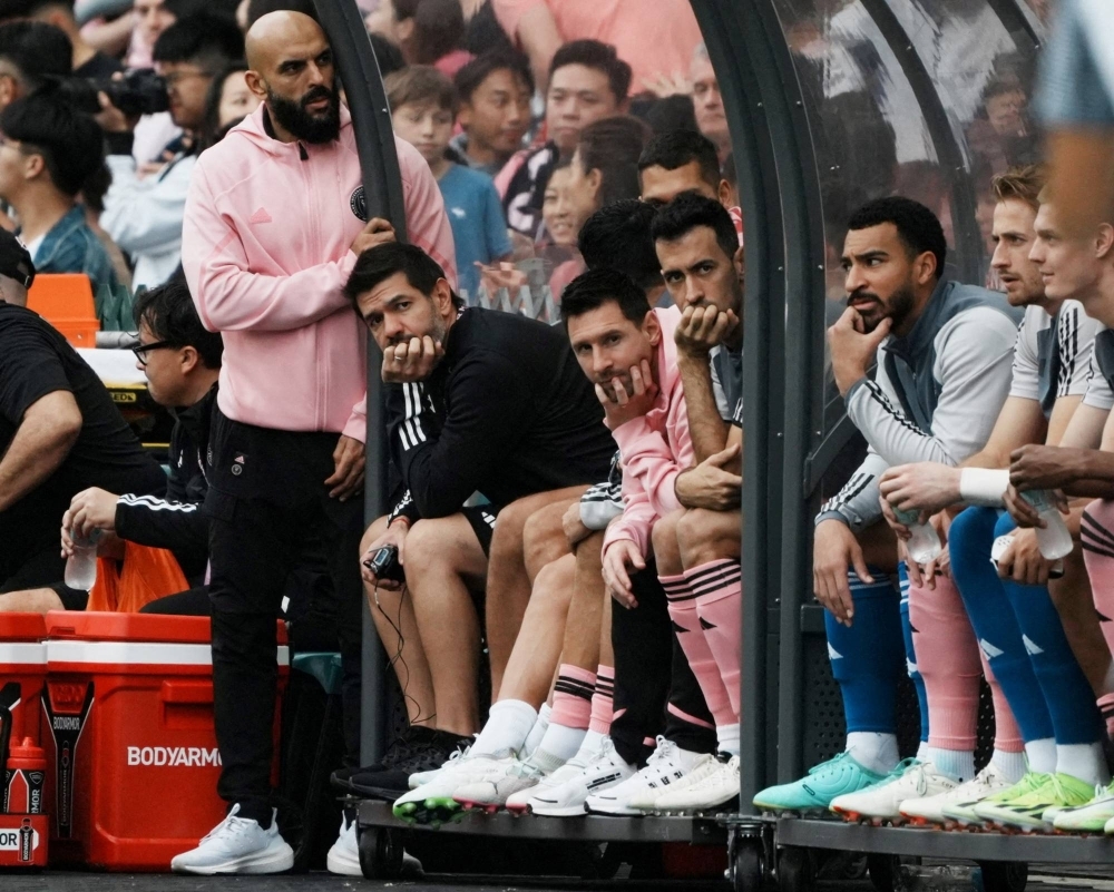 Inter Miami's Lionel Messi and teammates sit on the substitute bench during a match against a Hong Kong select XI in Hong Kong on Feb. 4.