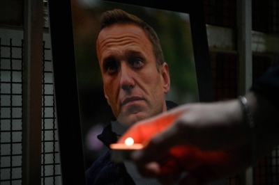 A person lights a candle by a portrait of late Russian opposition leader Alexei Navalny, who died in a Russian Arctic prison last week, at the entrance of Russian Embassy in Pristina, Kosovo, on Tuesday.