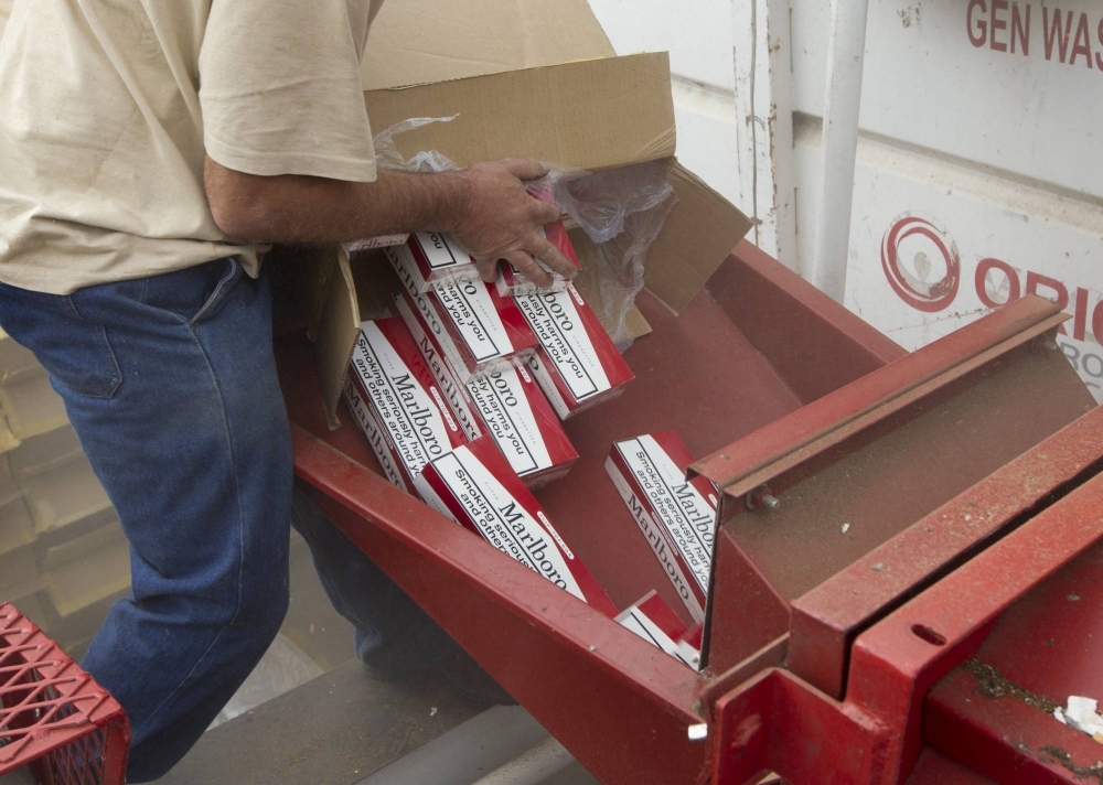 A government worker destroys counterfeit cigarettes in Durban, South Africa.