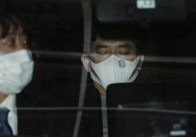 Film director Hideo Sakaki leaves the Akasaka Police Station in Tokyo on Wednesday as police take him to prosecutors.