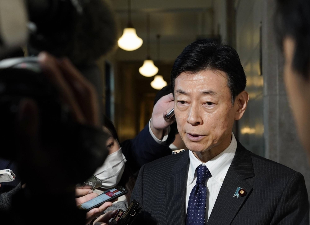 Former Industry Minister Yasutoshi Nishimura speaks to reporters in Tokyo on Wednesday.