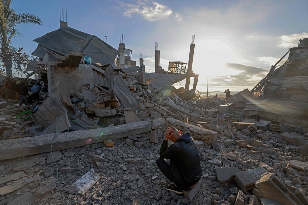 A man sits amid the debris of destroyed houses in the aftermath of Israeli bombardment in Rafah in the southern Gaza Strip on Wednesday. 