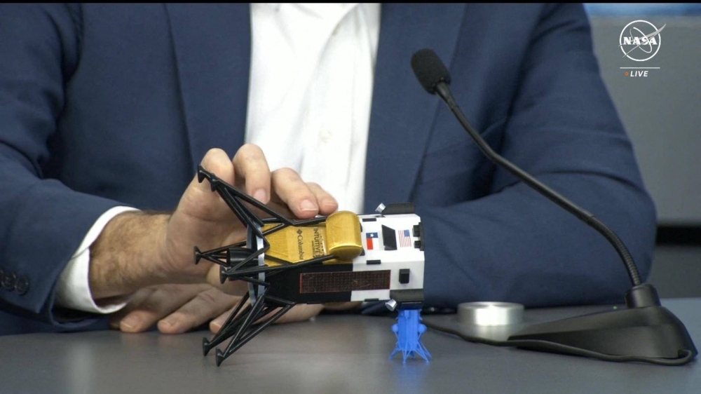 Intuitive Machines CEO Steve Altemus holds a model of the Odysseus lunar lander to show its position on the side, during a news conference at Johnson Space Center in Houston on Friday. 