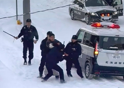 A photograph taken by a local resident shows a man being held down by police officers near a convenience store in Sapporo on Sunday.