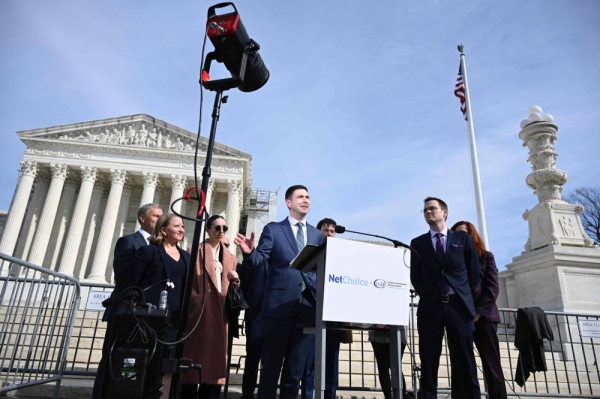 Chris Marchese (center), Director of NetChoice Litigation Center, speaks to the press outside the U.S. Supreme Court in Washington on Monday. In a case that could determine the future of social media in the United States, the U.S. Supreme Court was asked today to decide whether a pair of state laws that limit content moderation are constitutional.