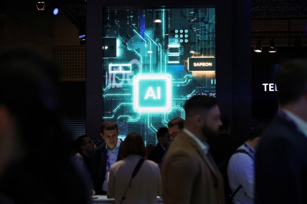 People walk past the booth of an AI chip company at the Mobile World Congress in Barcelona on Tuesday. 
